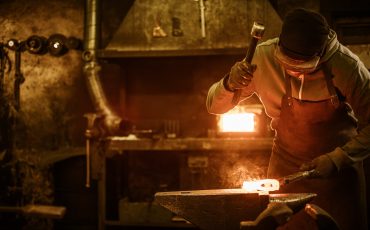blacksmith-forging-the-molten-metal-on-the-anvil-in-smithy